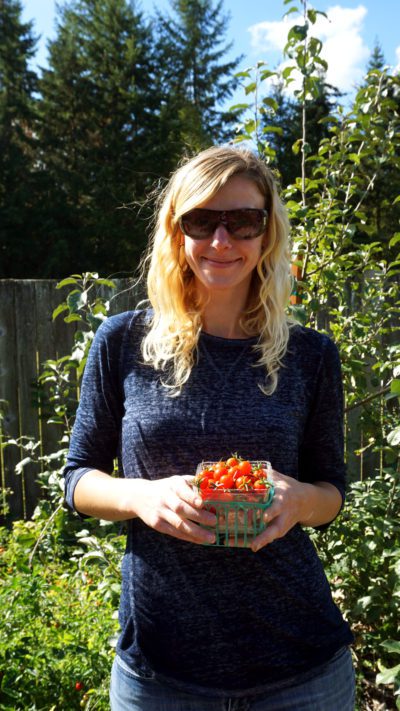 Harvest Kids coordinator Aramé Bailey holds a container of cherry tomatoes freshly picked from the garden.