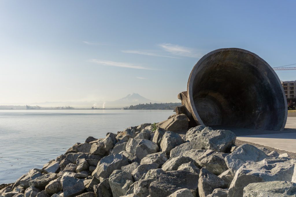 giant kettle sculpture sits at the edge of the peninsula with the bay and Mt. Rainier in the background