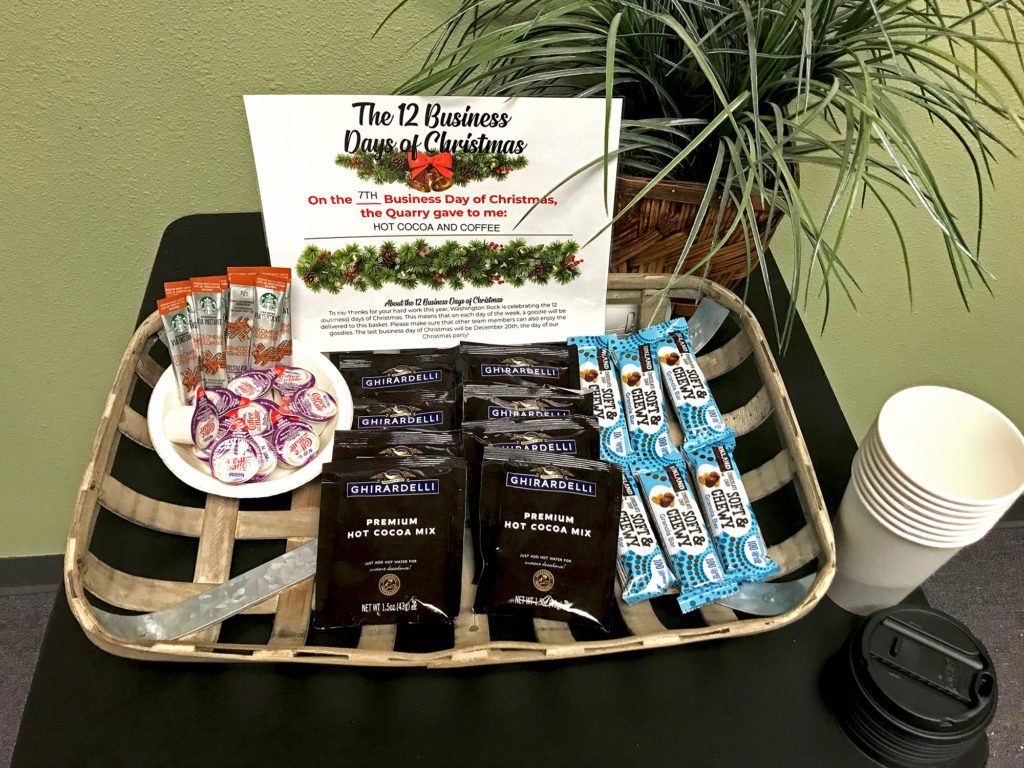 basket filled with packets of coffee and hot chocolate, along with granola bars and cups of creamer