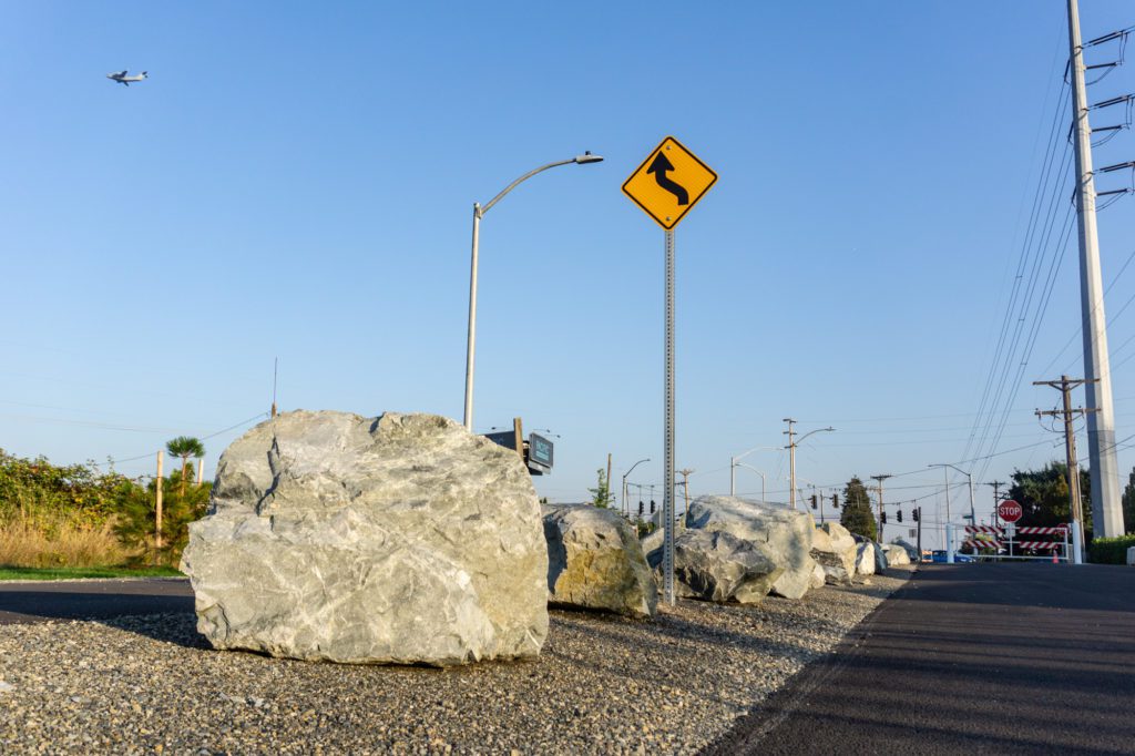 boulders lining paved trail