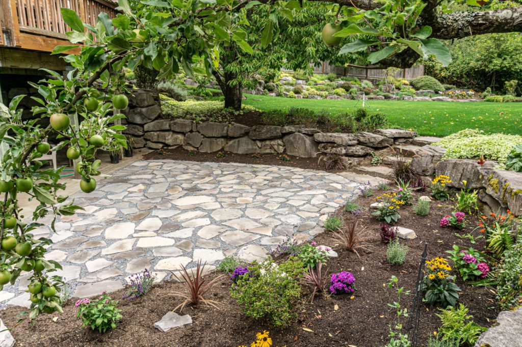flagstone patio surrounded by flowers