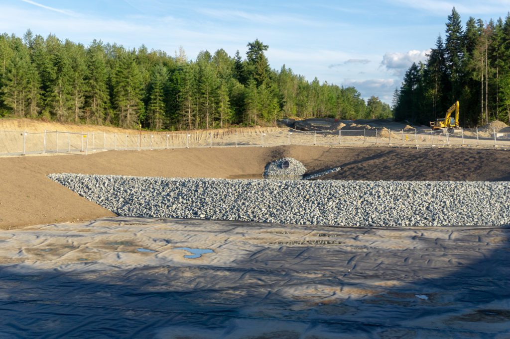 wall of large rocks extending across empty drainage basin