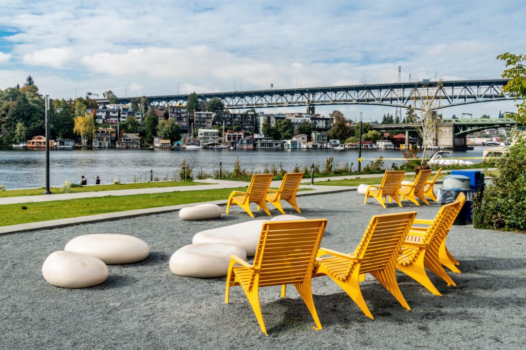 yellow steel chairs in a gravel patio facing University Bridge