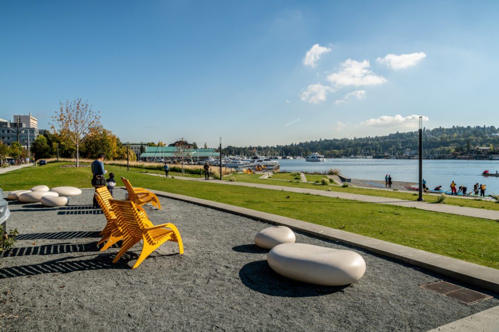 yellow steel chairs on a gravel patio with a view of Portage Bay