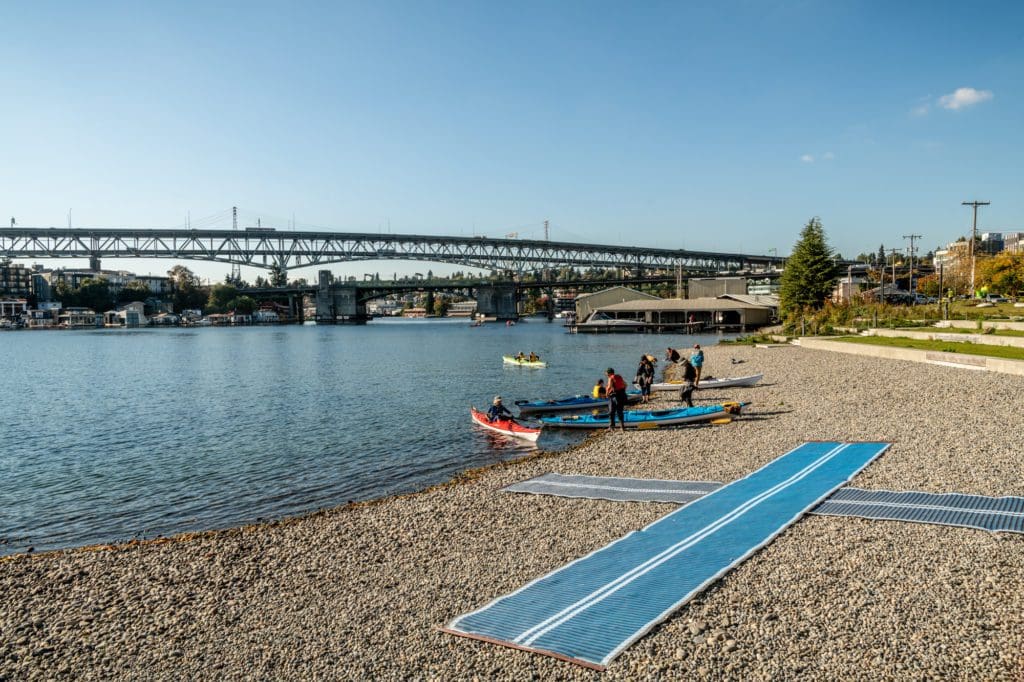 kayakers on a beach made up of round rocks