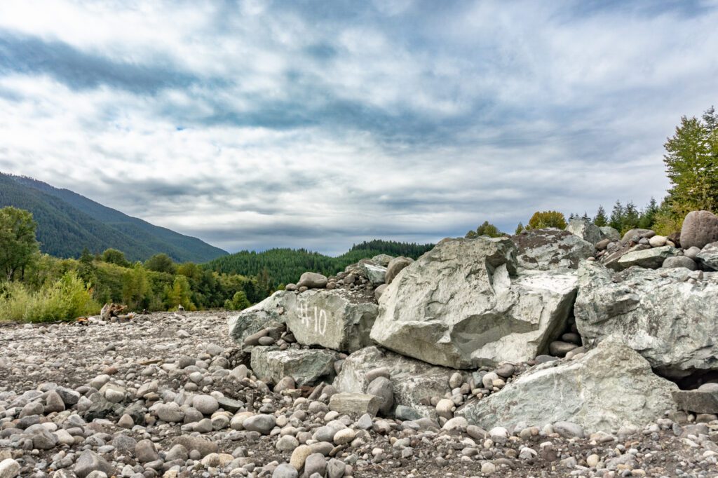 large boulders stacked on top of each other to create a deflector next to the Nisqually River levee