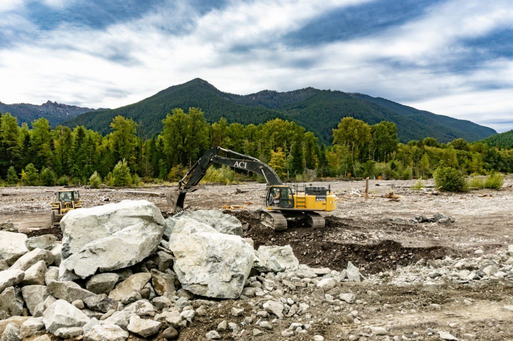 excavator working with large boulders near the Nisqually River levee