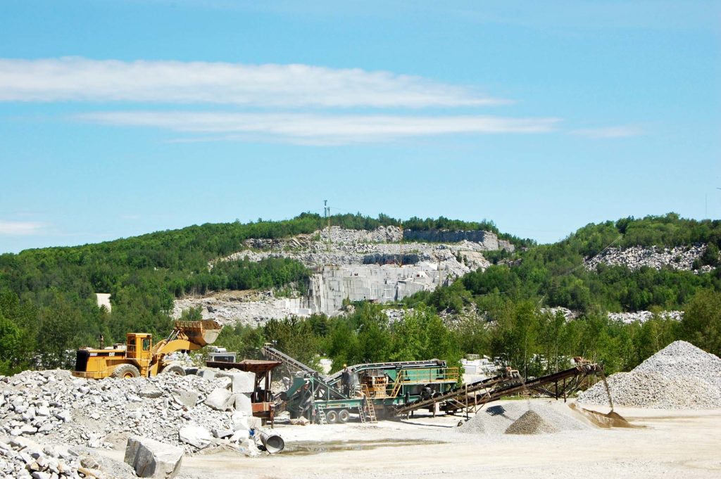 wheel loader dropping material into a crusher near a Vermont granite mine