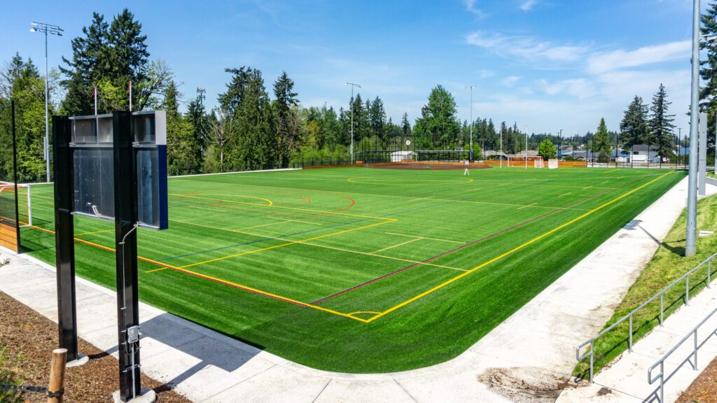 synthetic turf field with score board in foreground