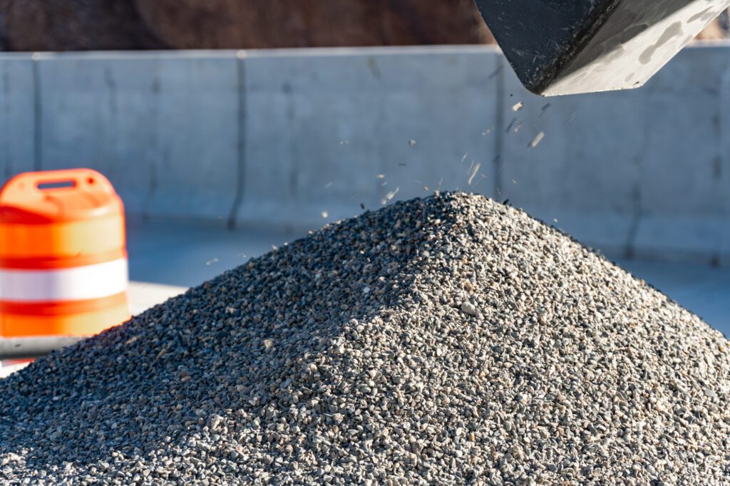 A closeup of Armorstone overlay aggregates, small stones, coming out of a chute.