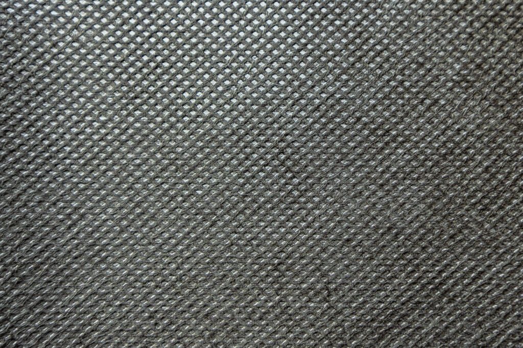 closeup of a piece of point bond fabric shows a repeating pattern of diamond shapes that have been heat sealed into the fabric