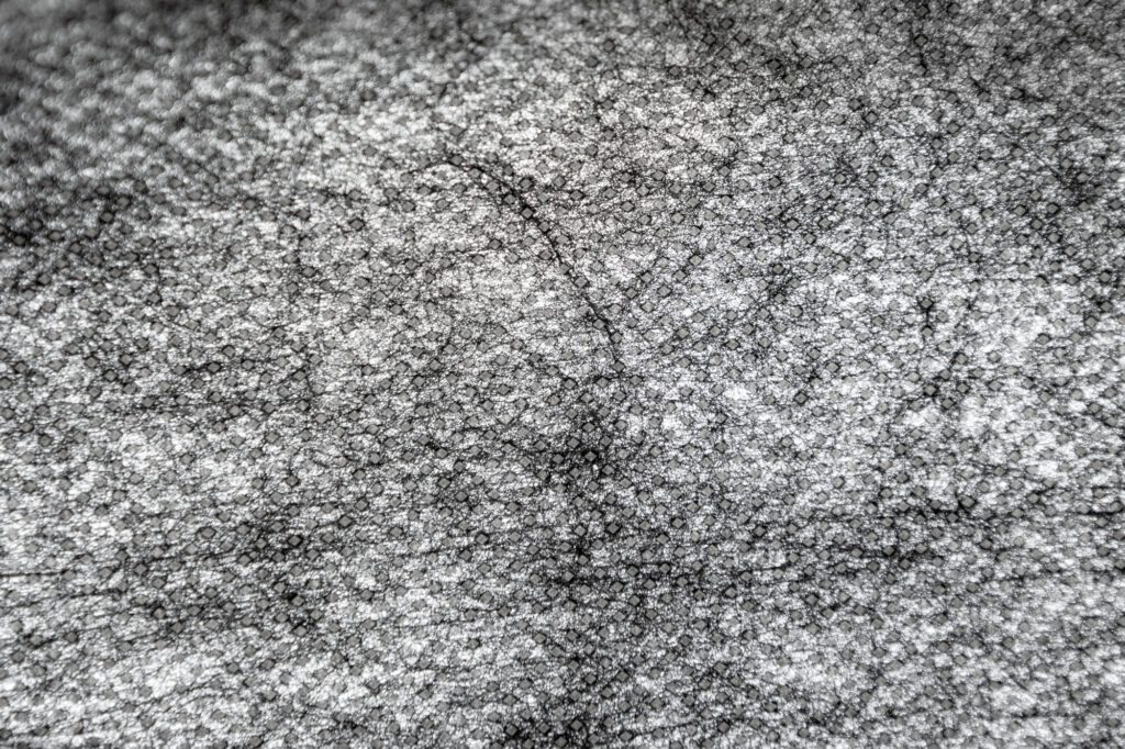 closeup of point bond fabric shows the fibers randomly combined with a pattern of sealed dots on top
