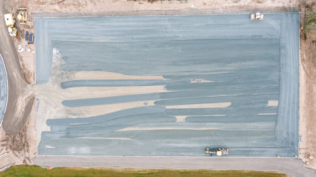 aerial photograph of crushed rock being spread to build a field