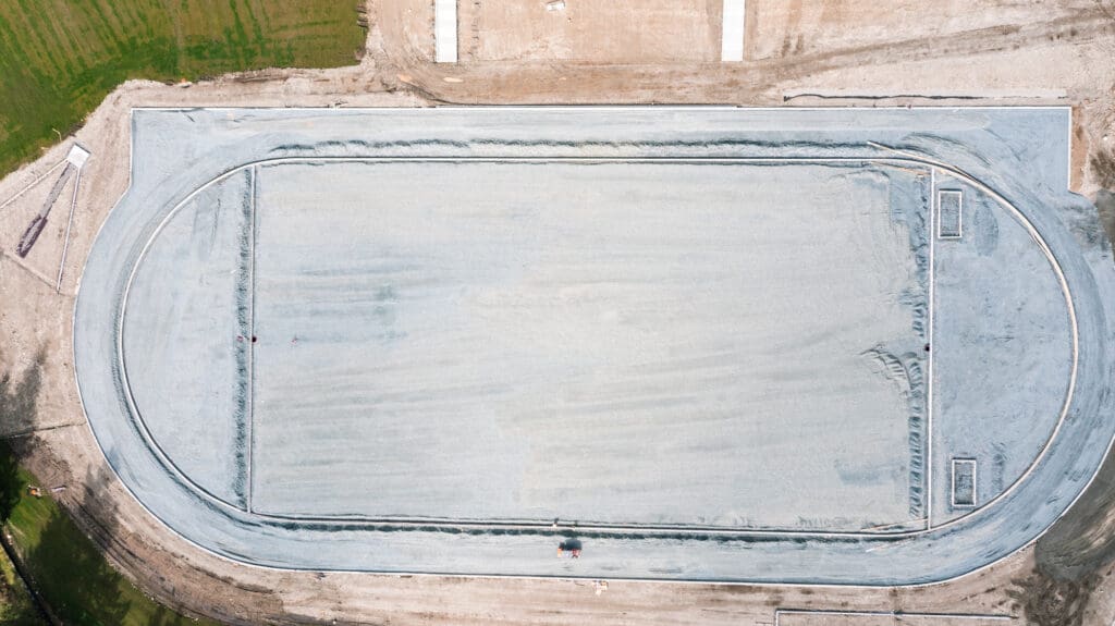 aerial photograph of crushed rock being spread over a field