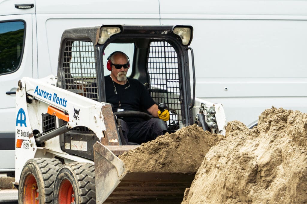 An operator retrieves a load of Ultrafine Sand with a skidsteer bucket.